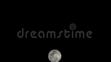 月圆在黑暗的天空和夜晚的乌云中快速上升